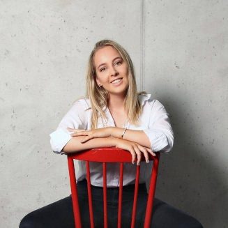 Melanie Koch sitzt auf rotem Stuhl quadratisches Format