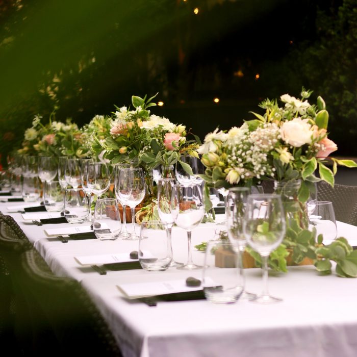 Hochzeitstafel draußen im Freien Farben Rosa und Grün mit hohen Blumengestecken